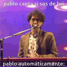 a man is singing into a microphone and playing a keyboard .