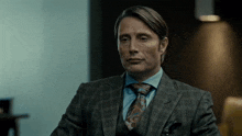 a man in a suit and tie is sitting down