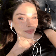 a woman wearing headphones and a black top is smiling for the camera