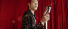 a man with red hair is standing in front of a microphone .