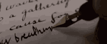 a person is writing a letter with a fountain pen