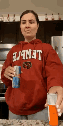a woman wearing a red hoodie that says lewis sits at a counter