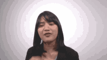 a woman with short hair is smiling and making a funny face .