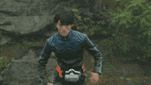 a man in a black and blue superhero costume is running on a bridge