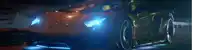a lamborghini is driving down a road at night with blue lights on .
