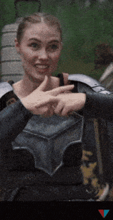 a woman in armor is giving a thumbs up sign