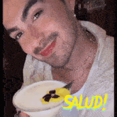 a close up of a man holding a plate with the word salud written in yellow