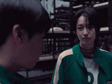 a girl in a green jacket with the letter r on the front
