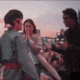 a man and a woman are standing next to each other with a crowd behind them