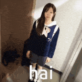 a girl in a school uniform is standing in a hallway with the word hai written on the floor behind her