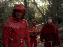 a man in a red costume is playing a guitar