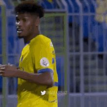 a soccer player wearing a yellow etihad airways shirt