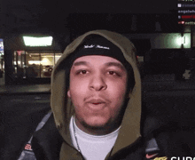 a man wearing a hoodie and a headband that says world famous on it