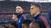 a group of men are standing in front of a crowd in a stadium with a sign that says beer and over rk .