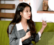 a woman in a plaid dress sits on a couch