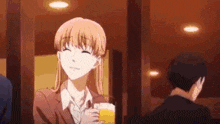 a woman in a suit is holding a glass of beer and smiling .