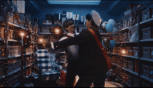 two men are hugging in a room filled with boxes