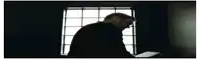 a bald man with a mustache is pointing at the camera .