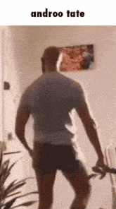 a man is standing in a room with the words androo tate written on the bottom