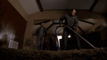 two men are cleaning a carpet in a dark room