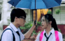 a boy and a girl are holding an umbrella over their heads .