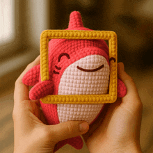 a person holding a stuffed animal with a yellow frame around it