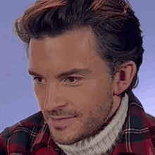 a man wearing a plaid shirt and a white turtleneck