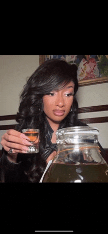 a woman is drinking from a pitcher while holding a glass
