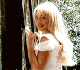 a blonde woman in a white dress is holding a shell