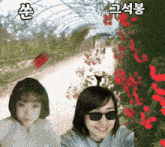 a woman wearing sunglasses is smiling in front of a greenhouse