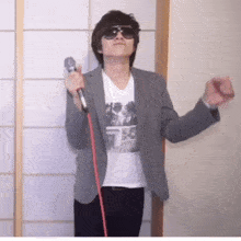 a man wearing sunglasses is holding a microphone in his hand
