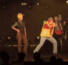 a group of people are dancing on a stage in front of an audience