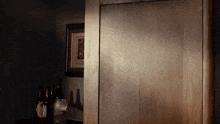 a dark room with bottles of alcohol and a picture on the wall .