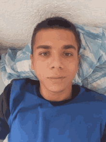 a young man in a blue shirt is laying down
