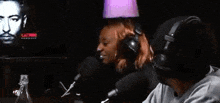 a man and a woman are sitting in front of a microphone in a room .