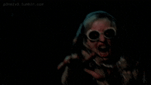 a person wearing sunglasses is screaming in a dark room with the website p3ns1v3.tumblr.com in the corner