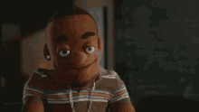 a close up of a puppet wearing a striped shirt and earrings .
