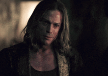 a man with long blonde hair and a black shirt