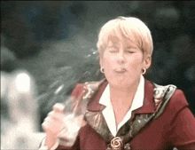 a woman in a red jacket is holding a glass of liquid