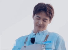 a man wearing a blue jacket with chinese writing on the front