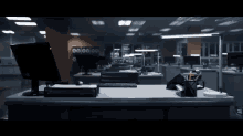 a computer monitor sits on a desk in an office with a clock on the wall that says 00:00:00