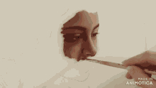 a person is painting a woman 's face with a brush and the words made in animotica on the bottom