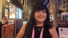a woman wearing a lanyard with a pink ribbon around her neck