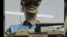 a man wearing a virtual reality headset is sitting in a room .