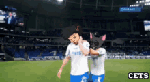 a couple of soccer players on a field with the word cets on the bottom