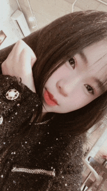 a close up of a girl 's face with a black jacket