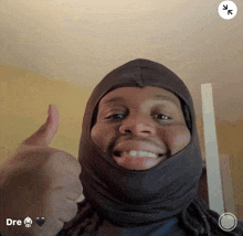 a man wearing a black hood giving a thumbs up with the word dre below him