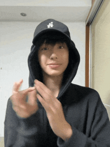 a man wearing a la hat and a hoodie