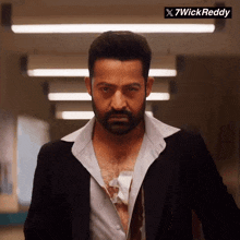 a man with a beard is wearing a black suit and a white shirt with the words 7wick reddy on the bottom