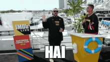 a man is standing in front of a sign that says hai